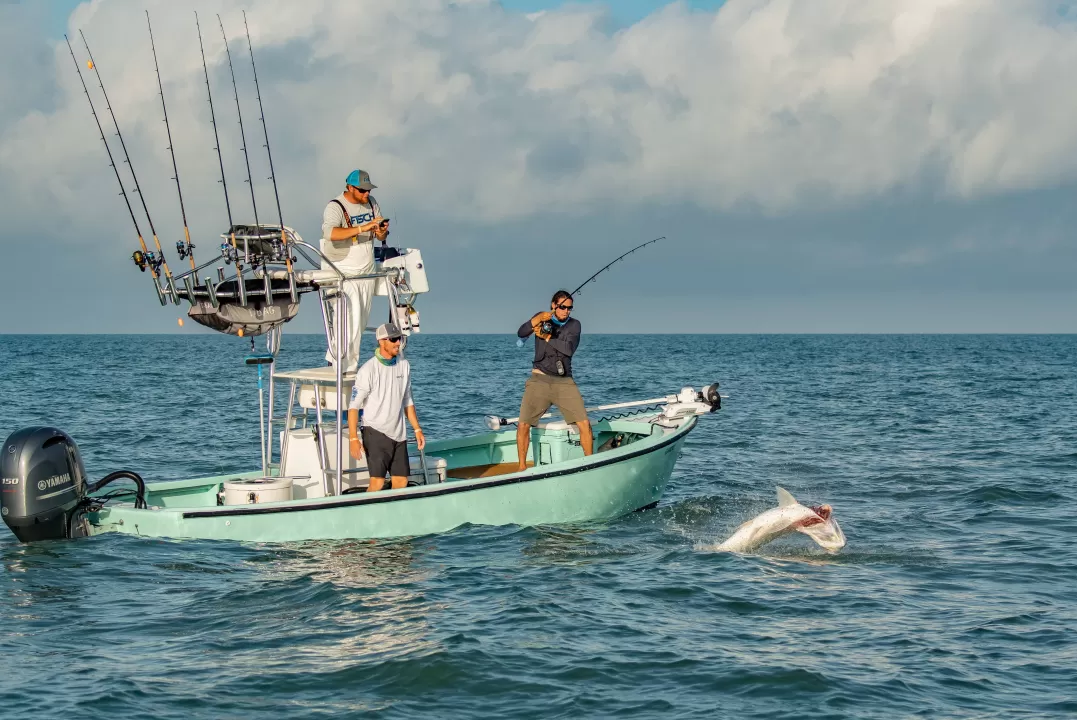 Men fishing reeling in tarpon