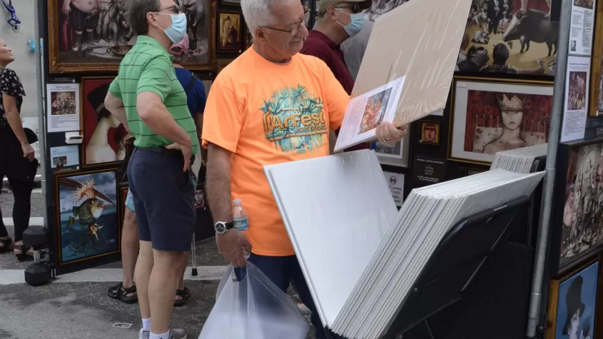 Attendee admiring an artist's work at ArtFest Fort Myers 2022