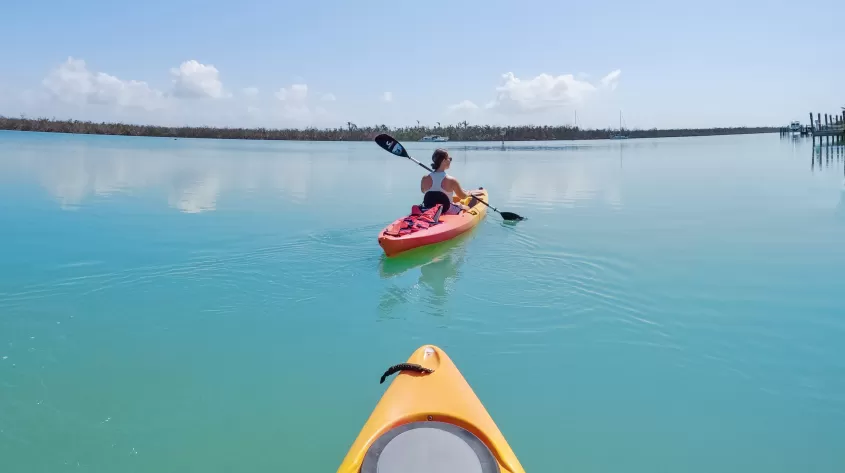 A man and woman riding kayaks on top of a body of water