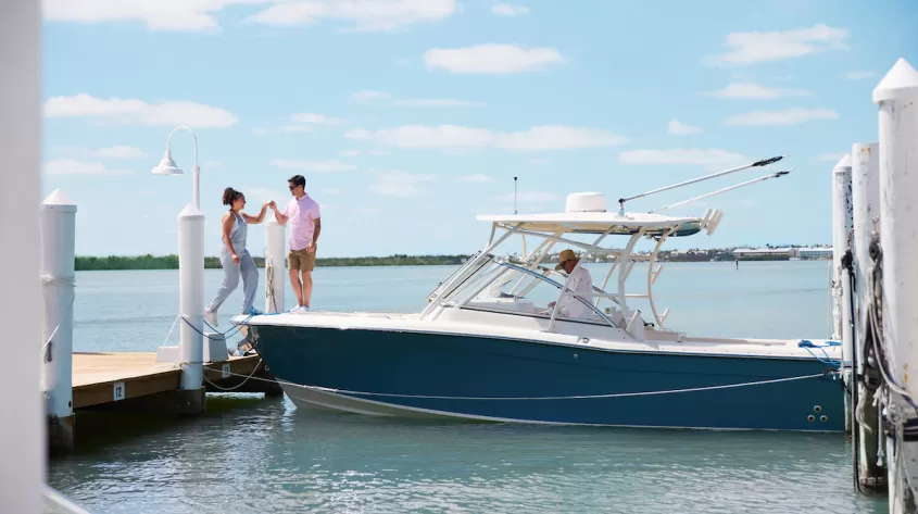 A couple boards a boat that is currently docked on Captiva Island 