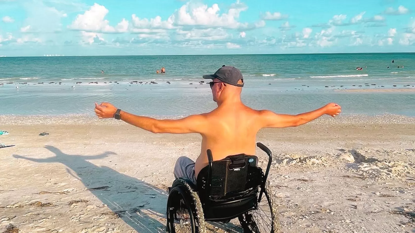 guy sitting in wheelchair on the beach