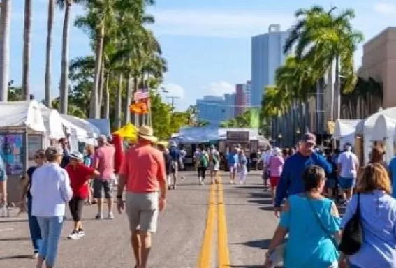 A group of people walking down a street next to tents