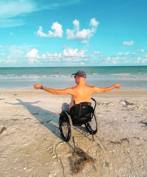 guy sitting in wheelchair on the beach